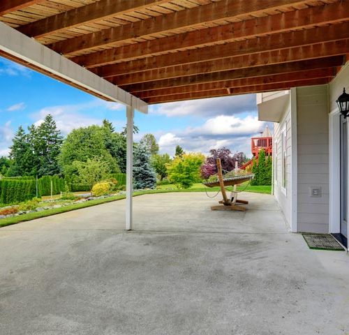 covered walkout patio with concrete floor, beautifully maintained garden