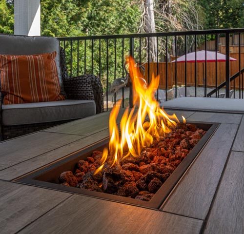 a spacious deck, close up of a fire pit table heater with stylish patio furniture