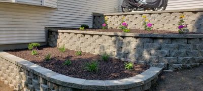 layer of block retaining walls with new flower shrubs, and top soil