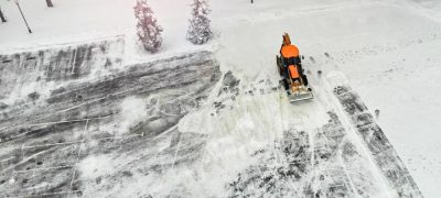 areal view of a snow removal tractor cleaning the streets from snow